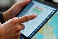 Expert consultation icon or image. A person planning a trip on a tablet.